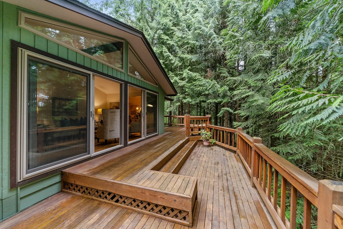 Holzterrasse an einem Haus mit großen Fenstern